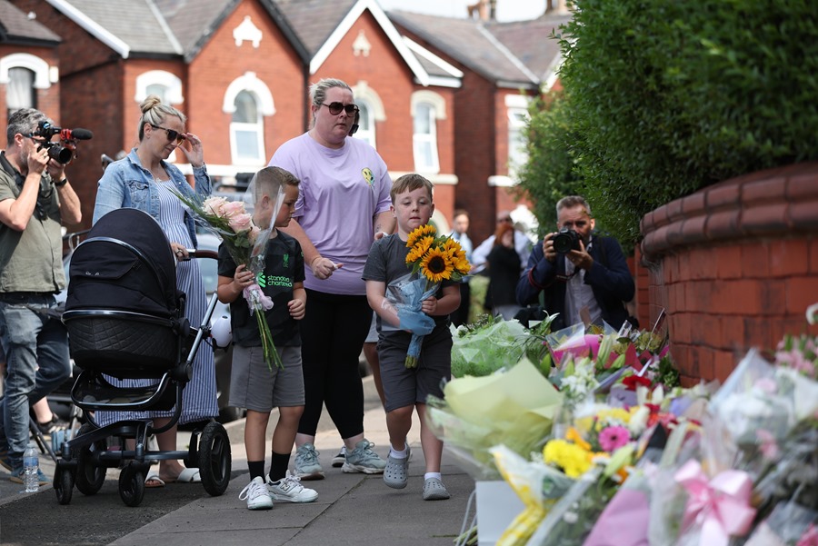 Unos niños depositan flores en el lugar en el que fueron apuñalados un grupo de menores en Hart Street en Southport, Gran Bretaña