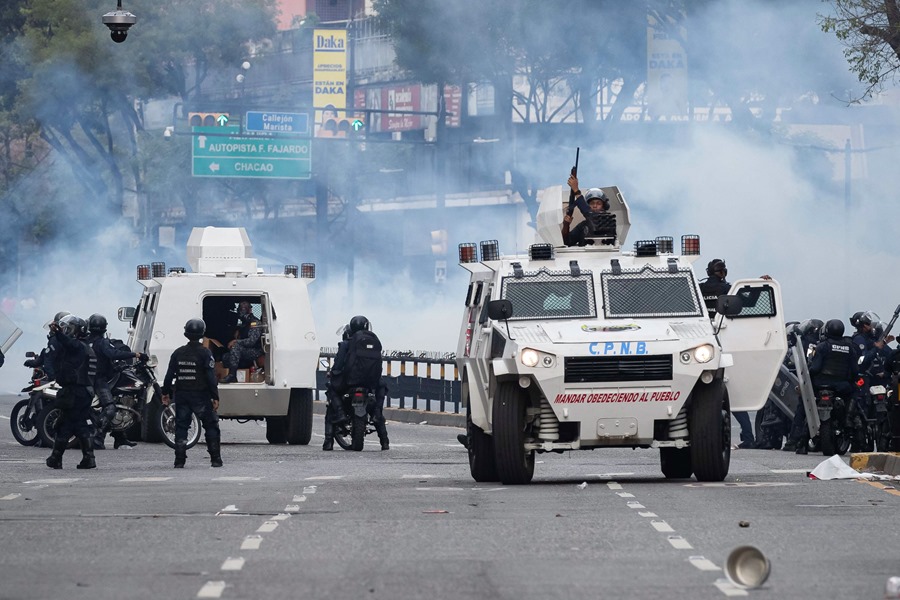 Agentes de la Policía Nacional Bolivariana (PNB) enfrentan a manifestantes opositores este lunes en Caracas