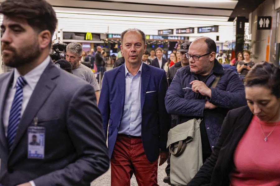 Nicolás Mangiarotti (c), encargado de negocios en la embajada de Argentina en Venezuela, llega al aeropuerto de Ezeiza (Buenos Aires).