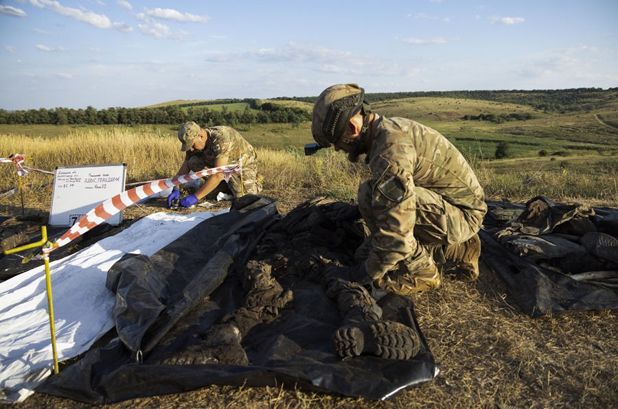 Miembros del grupo de búsqueda 'Platsdarm' de Ucrania trabajan en la exhumación e identificación de los cuerpos de militares rusos muertos cerca de una línea de frente en el área de Bakhmut, región de Donetsk, Ucrania.