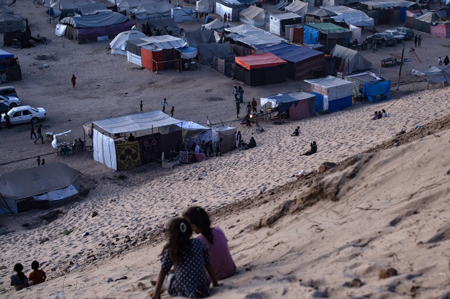 Palestinos desplazados que huyeron de sus hogares debido a los ataques aéreos israelíes y las órdenes de evacuación se refugian en un campament