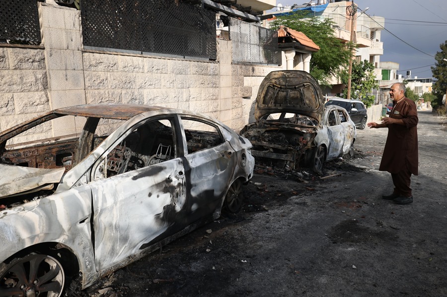 Un palestino mira los coches quemados después de que colonos israelíes incendiaran la aldea de Jeit, cerca de la ciudad de Qalqilya, en Cisjordania