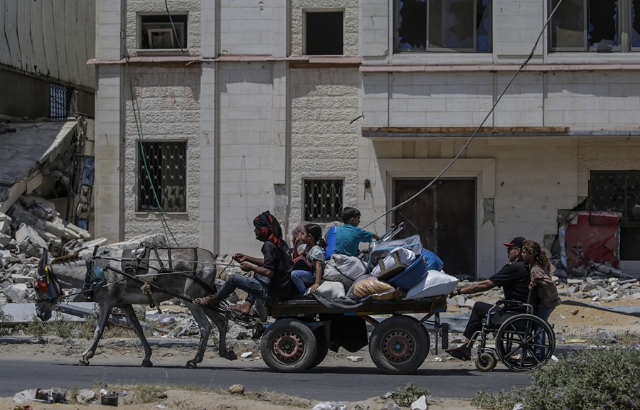 palestinos desplazados internos huyen con sus pertenencias tras una orden de evacuación emitida por el ejército israelí, en el campo de refugiados de Al Maghazi, en el centro de la Franja de Gaza,