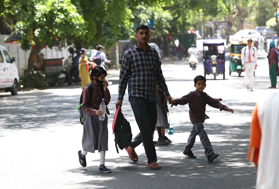 Escolares escoltados por sus padres en Nueva Delhi, India