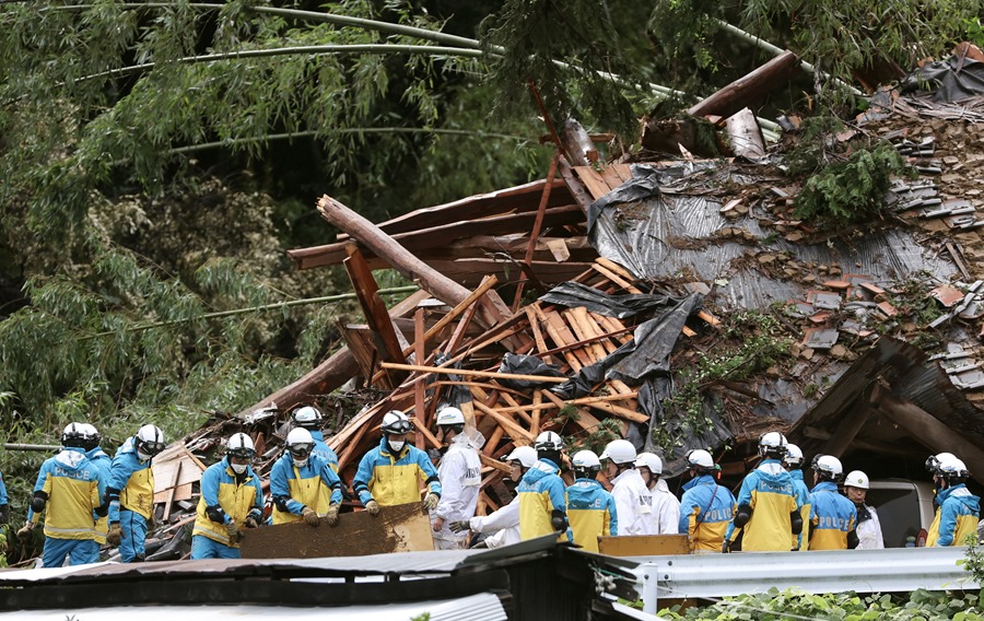 Los trabajadores de rescate buscan a residentes desaparecidos en medio de las ruinas de una casa que se derrumbó debido a las fuertes lluvias provocadas por el tifón Shanshan en Gamagori, Prefectura de Aichi