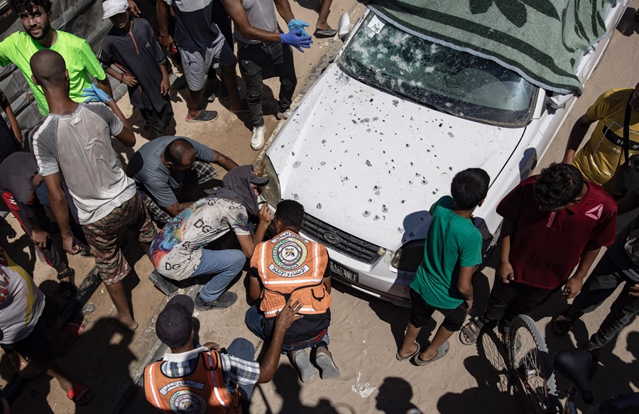 Palestinos inspeccionan un automóvil dañado después de un ataque aéreo israelí en la zona de Al-Mawasi, al sur de la Franja de Gaza