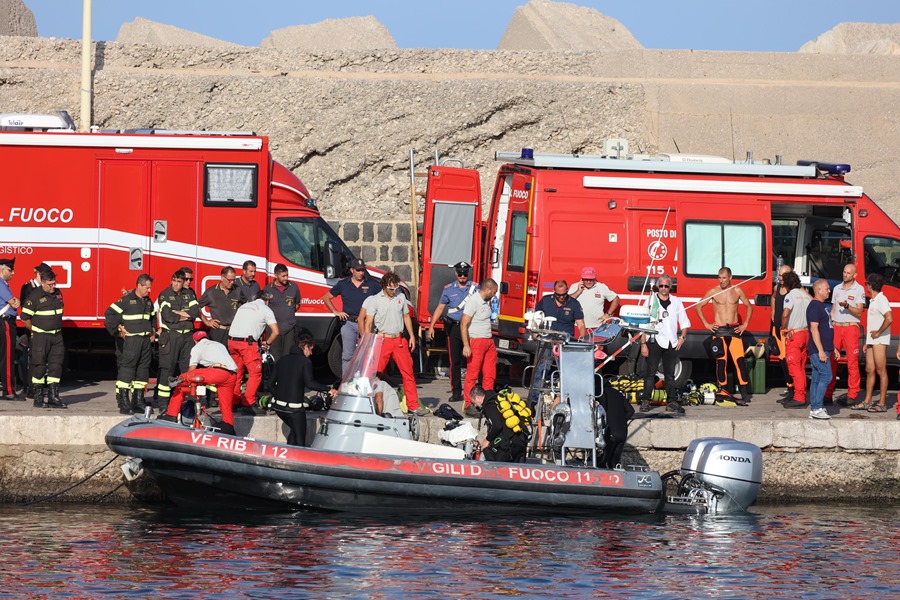 Trabajadores de rescate y buzos de los bomberos italianos mientras continúa una operación de rescate para las personas desaparecidas que estaban a bordo de un velero que se hundió, en Porticello, isla de Sicilia