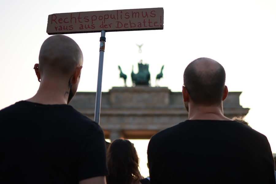 Un participante sostiene un cartel que dice "populismo de derecha fuera del debate" durante una protesta en conmemoración del ataque terrorista de Solingen en la Puerta de Brandenburgo