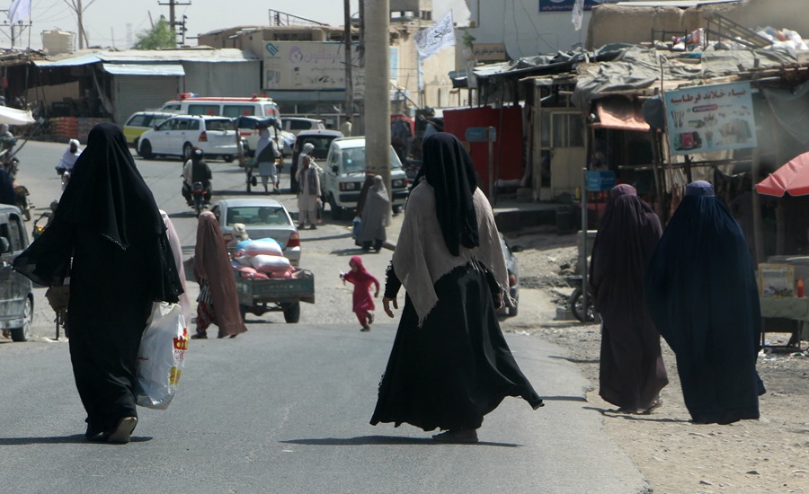 Mujeres afganas vestidas con burka caminan por una carretera en Kandahar