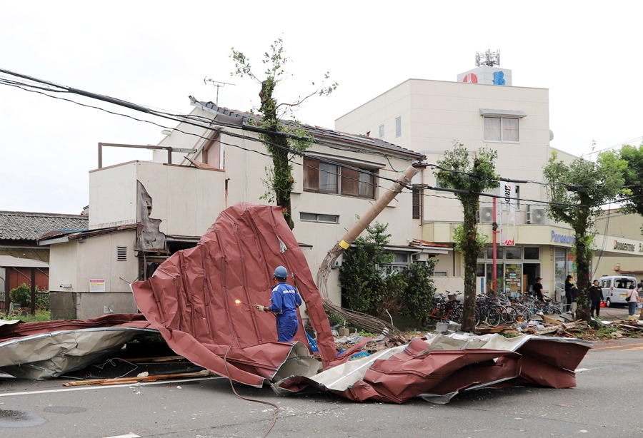 Un trabajador se encuentra sobre grandes escombros transportados por fuertes vientos generados por el tifón Shanshan en Miyazaki