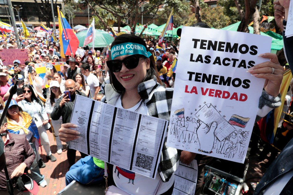 Una ciudadana venezolana sostiene carteles en una concentración para manifestarse en contra de los resultados oficiales de las elecciones en Venezuela que dieron la victoria al chavismo, este sábado, en Bogotá (Colombia). EFE/ Carlos Ortega