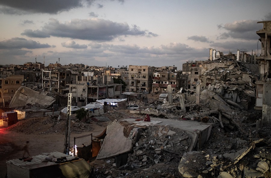 Palestinos entre los escombros de edificios destruidos en Jan Yunis, sur de la Franja de Gaza