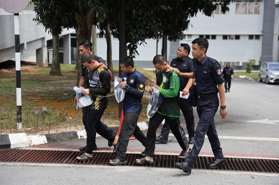 Tres miembros de Global Ikhwan Services and Business Holdings (GISBH) escoltados por agentes de la Policía Real de Malasia.