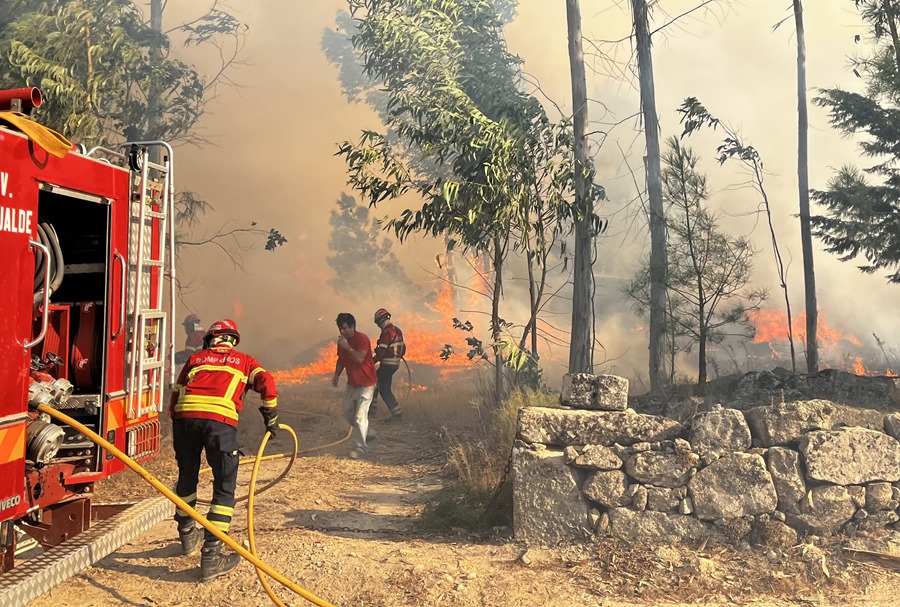 Vecinos y bomberos intentar sofocar las llamas que rodean la localidad portuguesa de Mesquitela