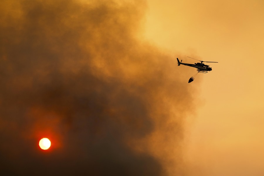 Un helicóptero que combate los incendios de Portugal en una densa nube de humo en Raiz Do Monte (Portugal).