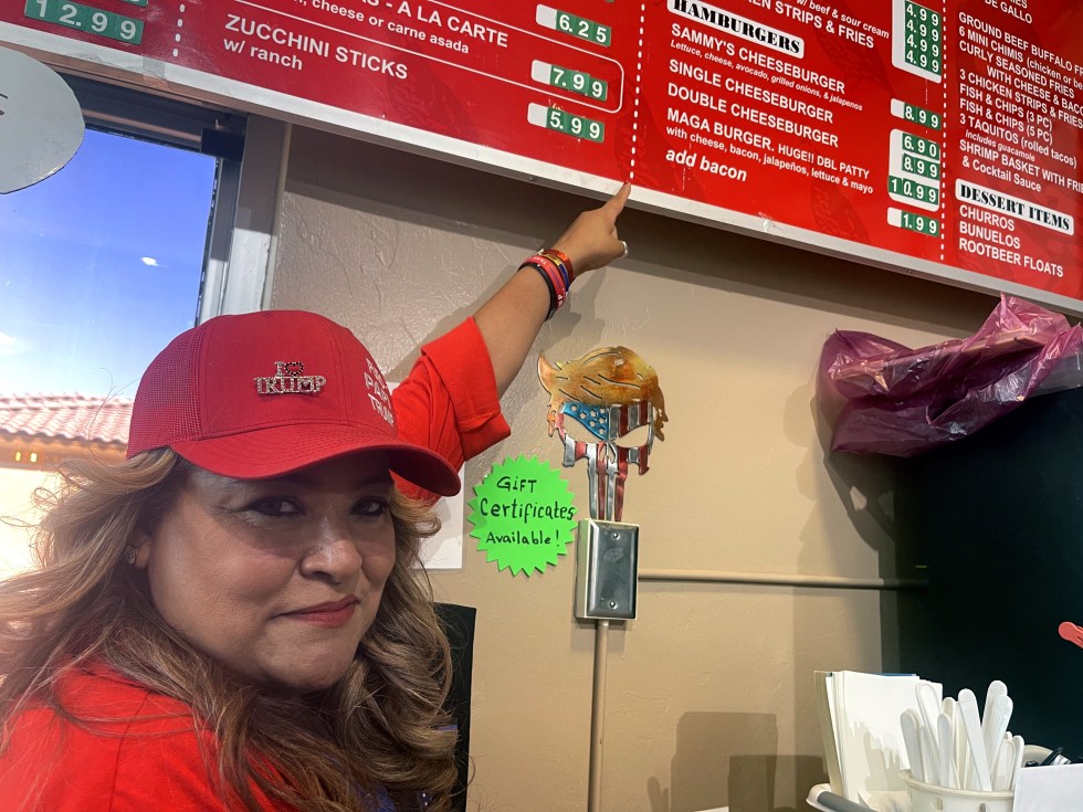 Fotografía del 28 de septiembre de 2024 de la mexicana Betty Rivas, señalando el costo de su hamburguesa 'MAGA Burguer', bautizada con las siglas de la campaña del expresidente Donald Trump 'Make America Great Again', en su restaurante Sammy's Mexican Grill, en Catalina, Arizona (Estados Unidos). EFE/ Ana Milena Varón