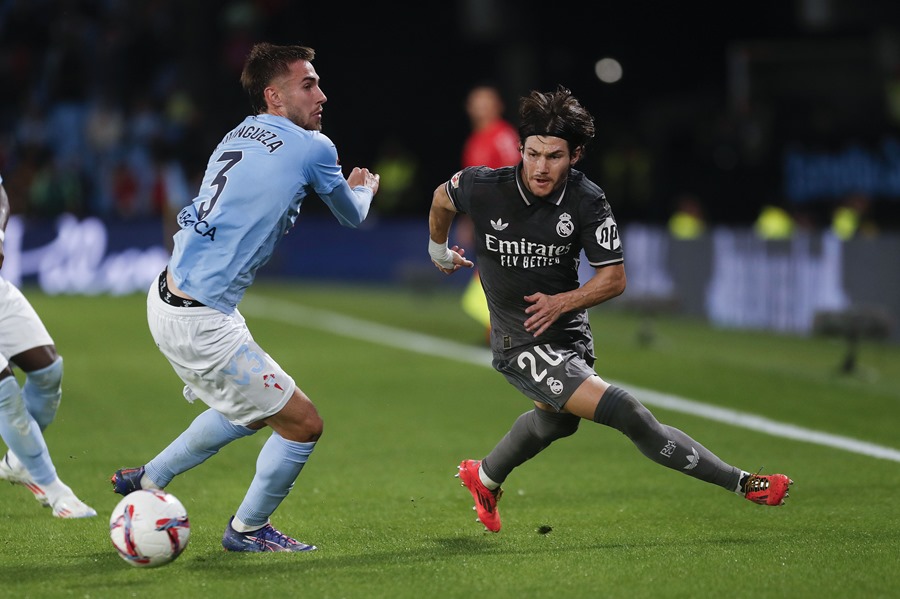 El centrocampista del Real Madrid Fran García (d), pelea un balón con Óscar Mingueza, del Celta, durante el partido de ayer