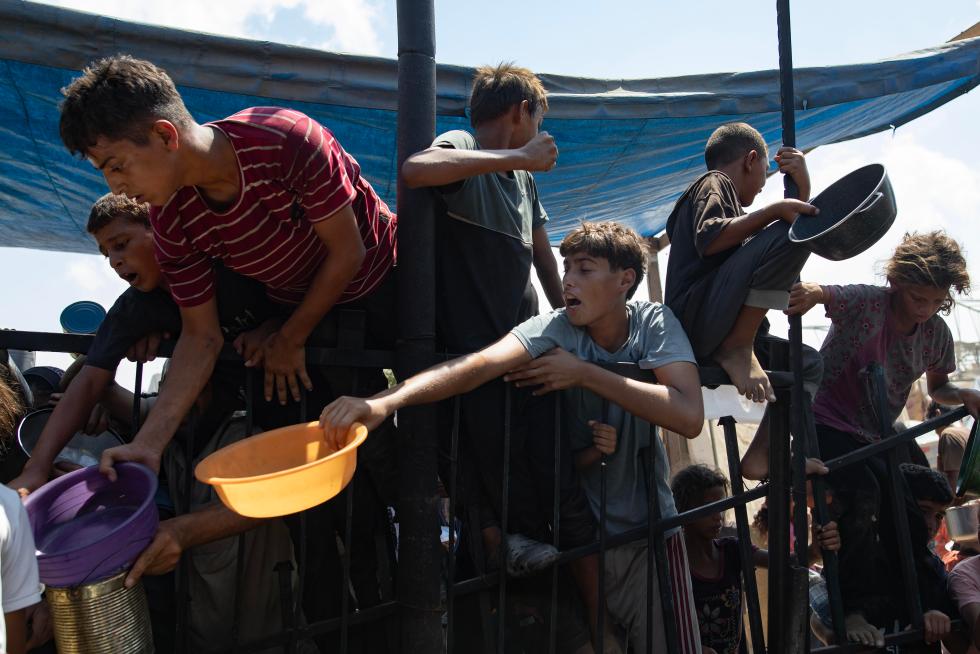 Personas desplazadas piden comida en un campo de ayuda humanitaria de la ONU, en una fotografía de archivo. EFE/Haitham Imad