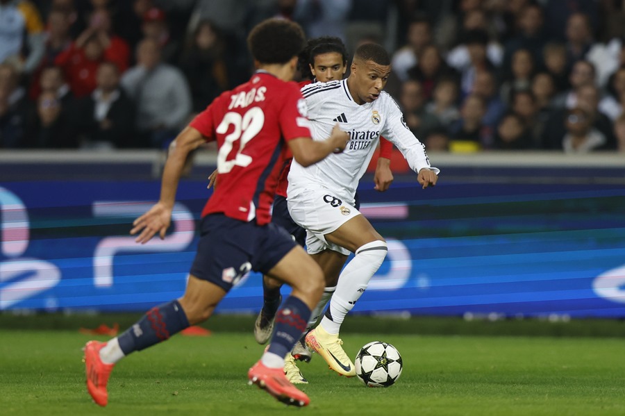 Tiago Santos (i) del Lille en acción contra Kylian Mbappe (d) del Real Madrid durante el partido de Liga de Campeones