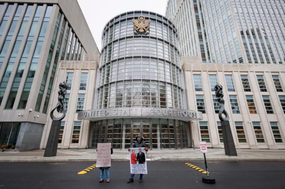 Personas sostienen carteles con imágenes del exsecretario de Seguridad Pública mexicano Genaro García Luna, este 21 de febrero de 2023, en el Tribunal Federal del Distrito Este de Nueva York.EFE/Justin Lane