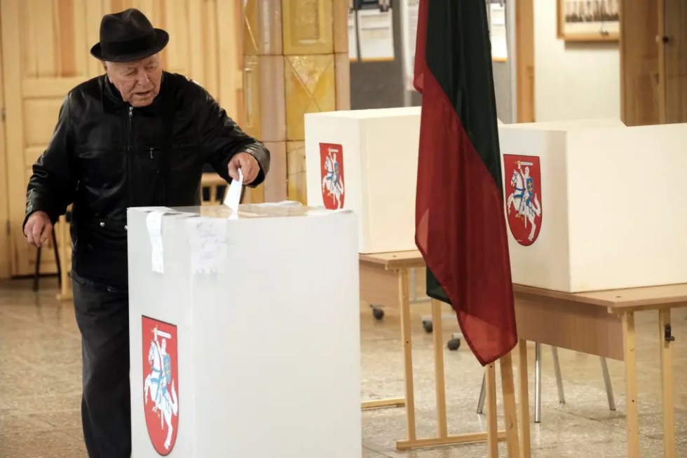 Un hombre introduce su papeleta durante la segunda vuelta de las elecciones parlamentarias en Panevezys, Lituania.