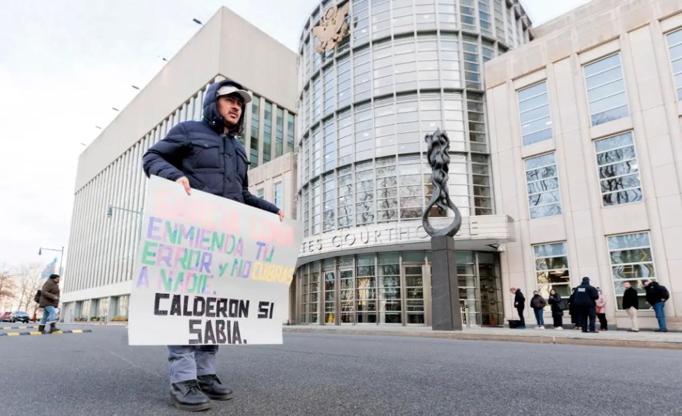 Un hombre sostiene un cartel en el tribunal federal donde se llevará a cabo el juicio a Genaro García Luna, exsecretario de Seguridad Pública de México, en el distrito de Brooklyn, en Nueva York (EE.UU.), este 17 de enero de 2023. EFE/EPA/Justin Lane