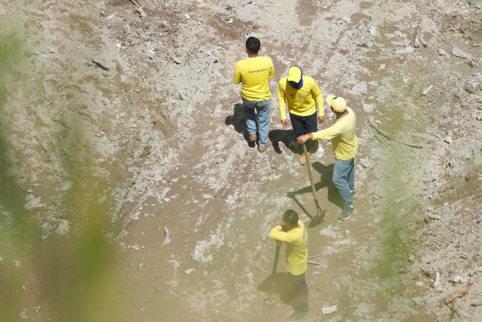 Fotografía del 4 de octubre de 2024 donde se observa a presos en fase de confianza, policías y forenses excavando en fosas clandestinas en Tonacatepeque (El Salvador). EFE/ Rodrigo Sura