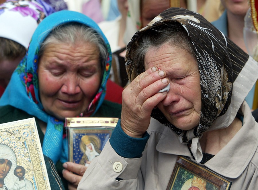 Ancianas ucranianas con iconos en sus manos lloran durante una reunión de protesta en el centro de Kiev