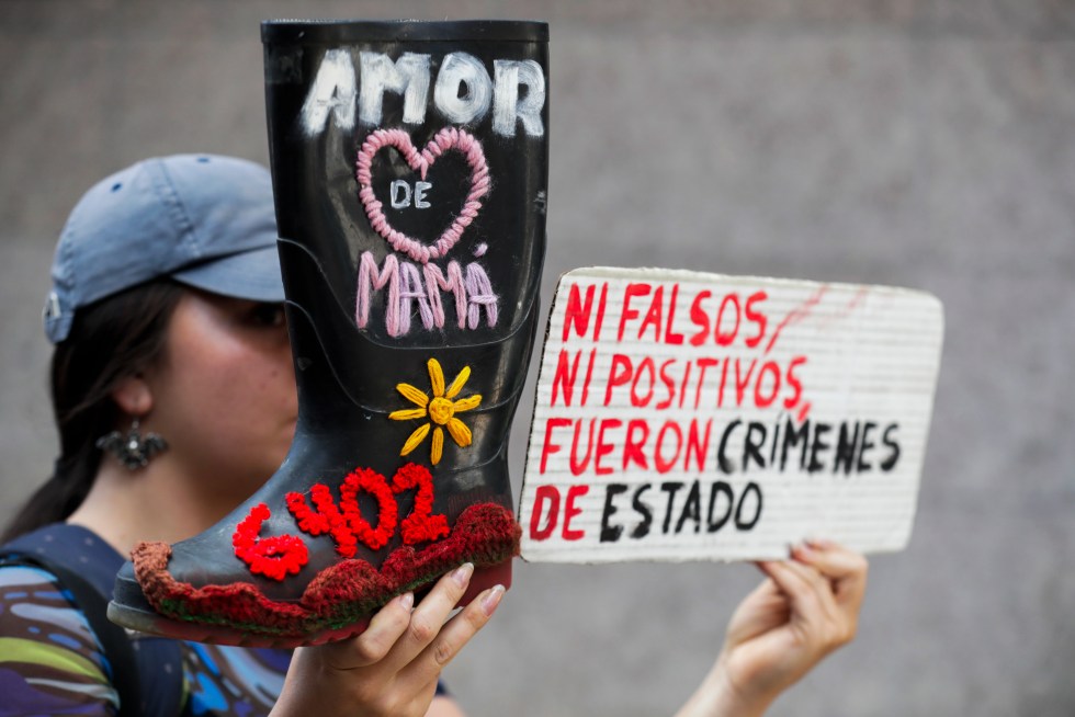 Una mujer sostiene una bota durante una protesta simbólica por las víctimas de ejecuciones extrajudiciales o falsos positivos en Bogotá, Colombia.