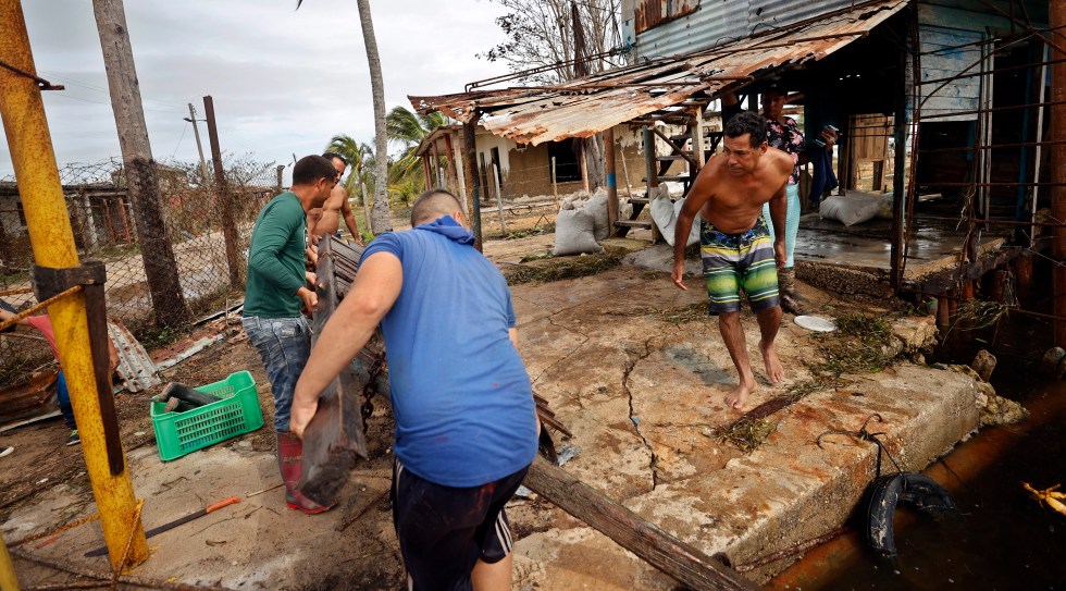 Unas personas recogen escombros tras el paso del huracán Rafael, el 7 de noviembre de 2024, en Playa Majana, en la provincia de Artemisa (Cuba). EFE/ Ernesto Mastrascusa