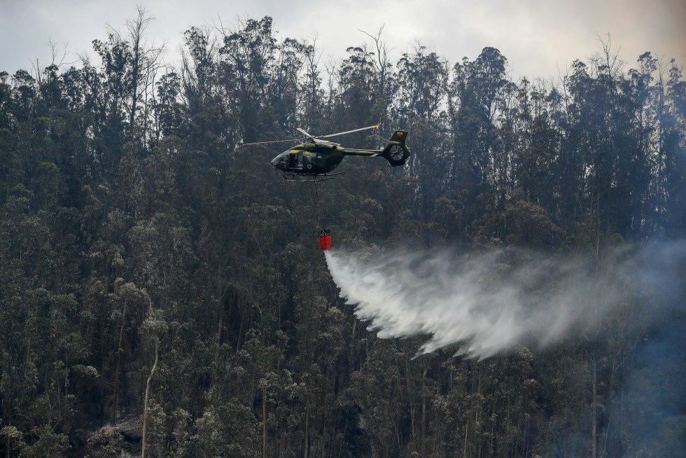 Un helicóptero descarga agua para apagar un incendio en el Cerro Auki, en Quito (Ecuador), en una fotografía de archivo. EFE/ José Jácome