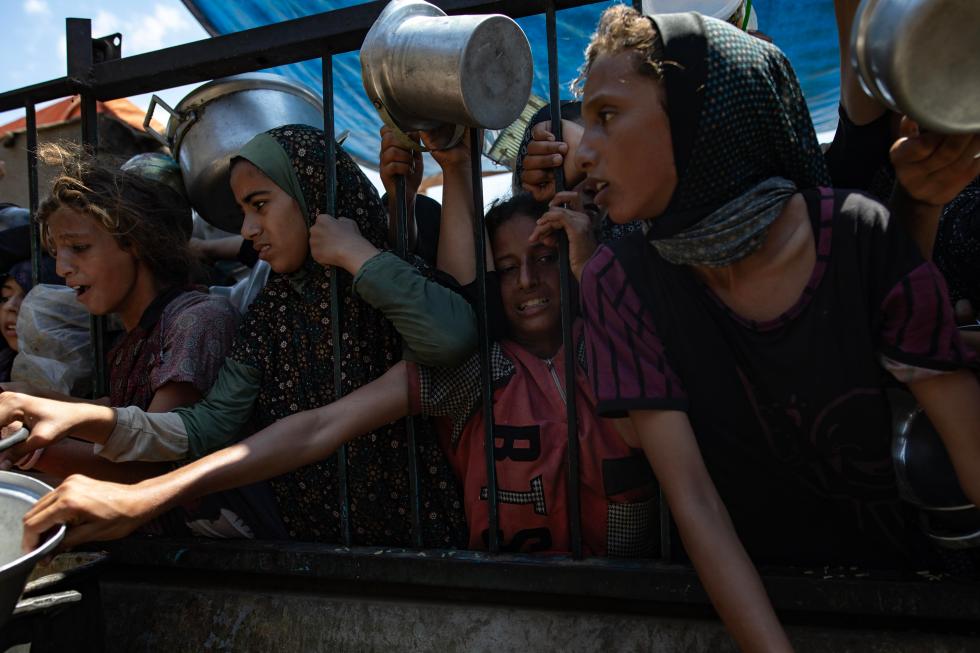 Personas desplazadas piden comida en un campo de ayuda humanitaria de la ONU, en una fotografía de archivo. EFE/Haitham Imad