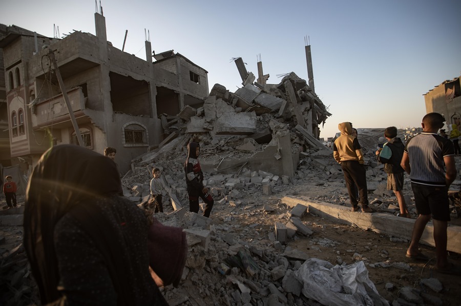 Palestinos inspeccionan los escombros de un edificio destruido tras un ataque aéreo israelí, en Khan Yunis, en el sur de la Franja de Gaza.