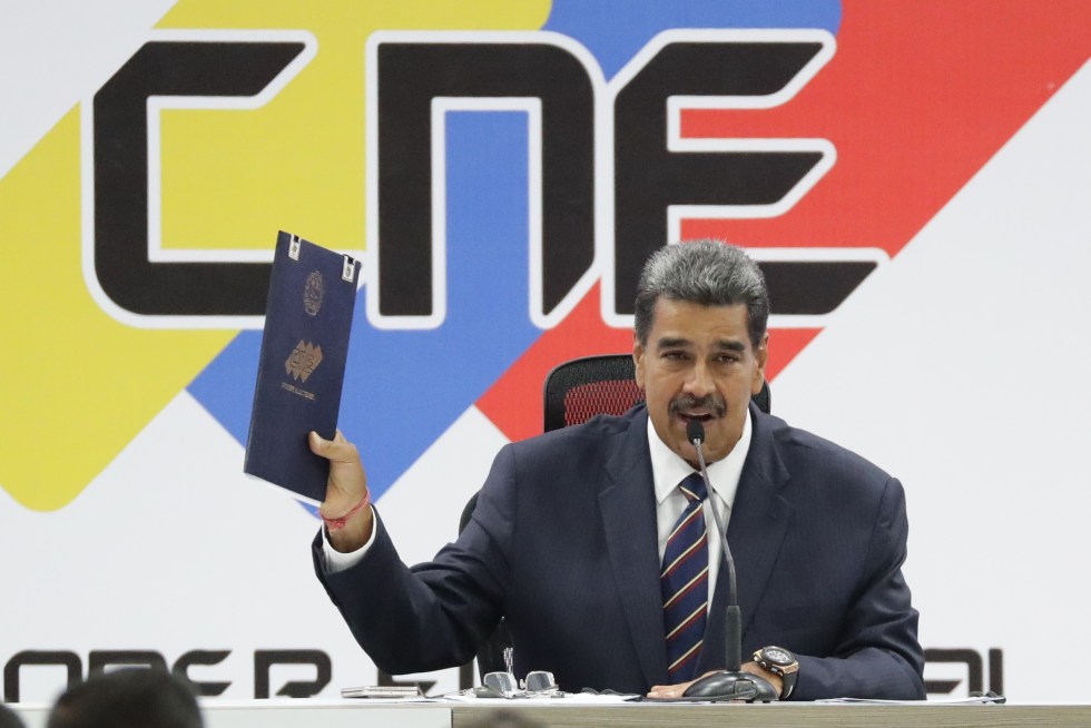 El presidente de Venezuela, Nicolás Maduro, sostiene el acta de juramentación del presidente electo entregada por el presidente de Consejo Nacional Electoral (CNE), Elvis Amoroso (no en la foto), este lunes, en Caracas (Venezuela). EFE/ Ronald Peña R.