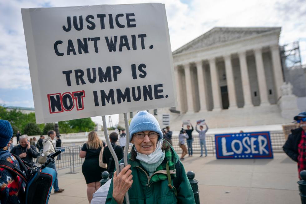 Vista de una persona que muestra un mensaje en contra de la inmunidad de Donald Trump, afuera del Tribunal Supremo de EE.UU., en una fotografía de archivo. EFE/Shawn Thew