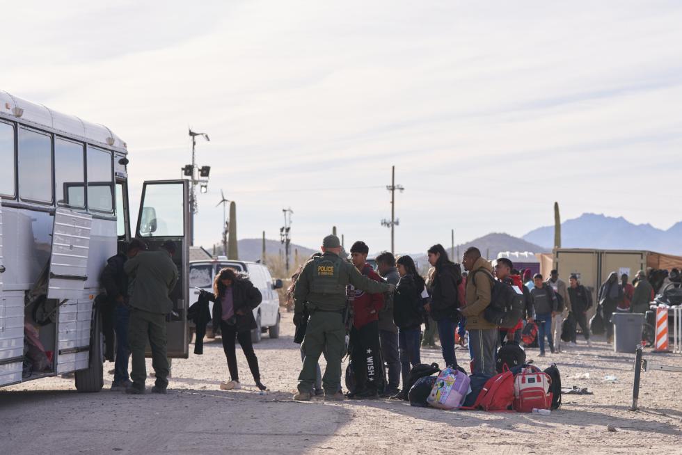 Migrantes indocumentados suben a un autobús ante la vigilancia de la Patrulla Fronteriza de EE.UU., en una fotografía de archivo. EFE/Allison Dinner