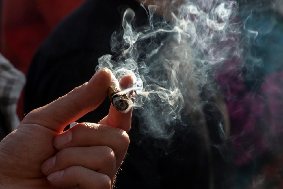 Vista de una persona que fuma un cigarrillo de cannabis, en una fotografía de archivo. EFE/Sarah Yenesel