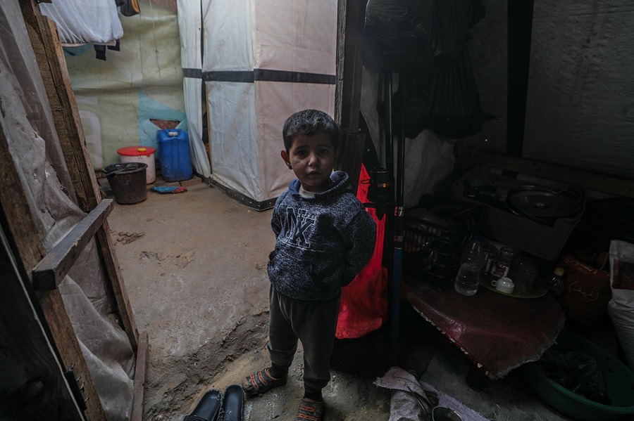 Un niño palestino desplazado internamente se encuentra dentro de su tienda familiar en un día ventoso al oeste de Deir Al Balah, en el centro de la Franja de Gaza