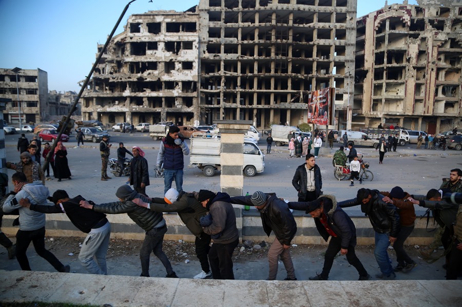 Soldados del régimen sirio son trasladados por soldados rebeldes en Homs.