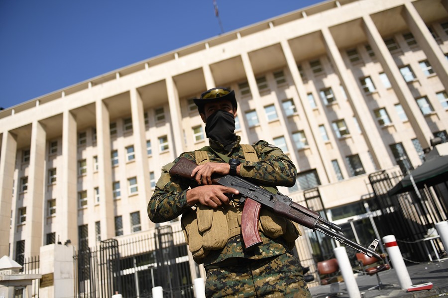 Un rebelde armado hace guardia en una calle de Damasco, Siria