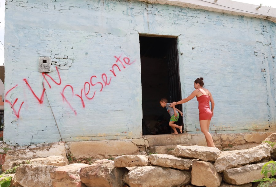 Fotografía de archivo de una mujer y un niño que entran a una casa marcada con un grafiti del grupo guerrillero del ELN, uno de los responsables de la violencia en el Catatumbo, en el noreste de Colombia. EFE/ Mario Caicedo