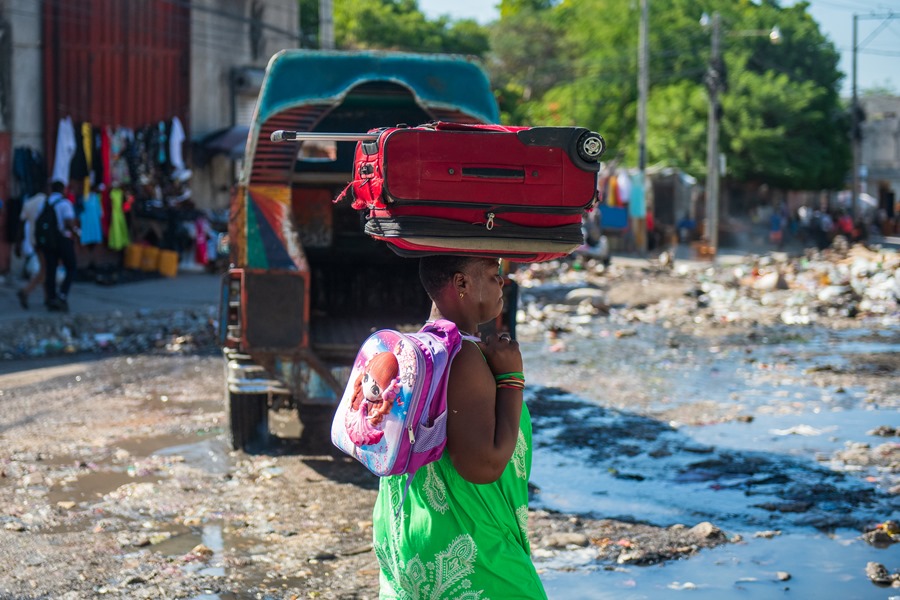 Fotografía de archivo de una mujer que camina con sus pertenencias en una calle de Poste Marchand, en Puerto Príncipe (Haití). EFE/ Johnson Sabin