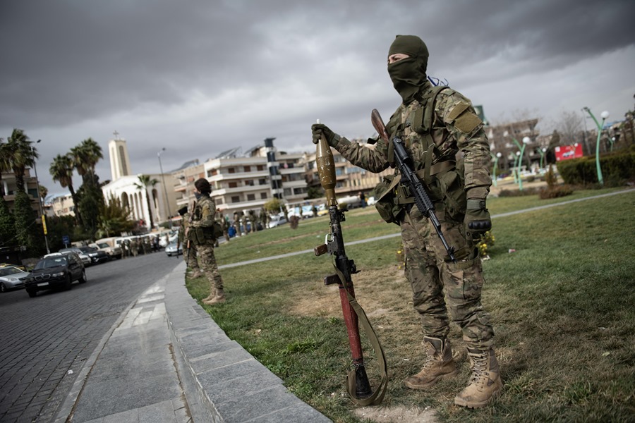 Los combatientes de la oposición siria aseguran la zona durante un desfile militar en Damasco, Siria