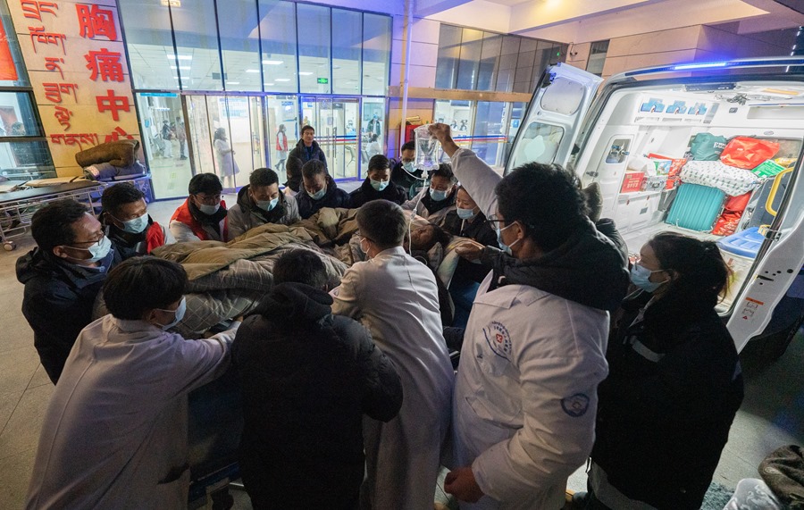 Los trabajadores médicos trasladan a un residente mayor herido en un terremoto a la sala de emergencias del Hospital Popular de Xigaze