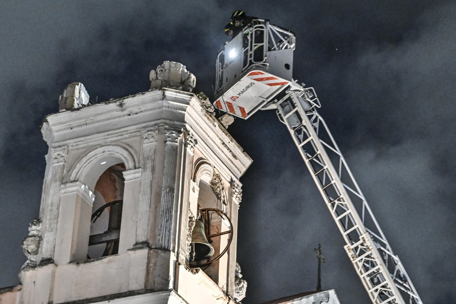Los bomberos inspeccionan el campanario de la iglesia de Santa Ana tras un terremoto en Bagnoli