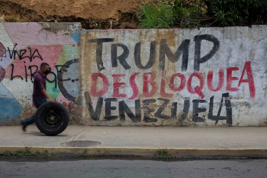 venezuela-migrantes2 Personas caminan frente a un graffiti que dice "Trump Desbloquea Venezuela", en Caracas (Venezuela). EFE/ Rayner Peña