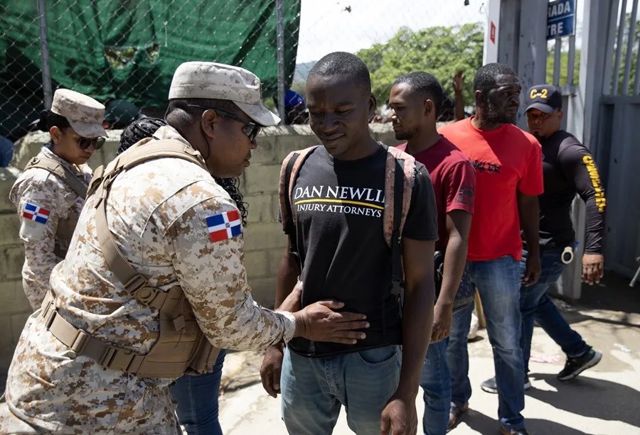 republica-dominicana-haiti2 Un integrante del Cuerpo Especializado de Seguridad Fronteriza Terrestre de República Dominicana requisa a un hombre antes de su deportación a Haití este lunes, en Elías Piña. EFE/ Orlando Barría