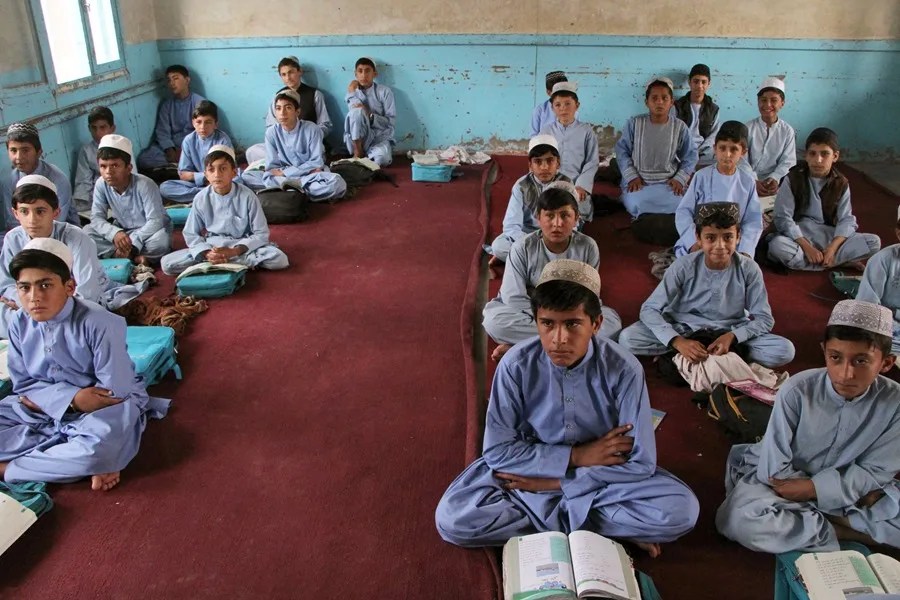 talibanes Estudiantes afganos con uniformes tradicionales asisten a clase en una escuela pública en Kandahar