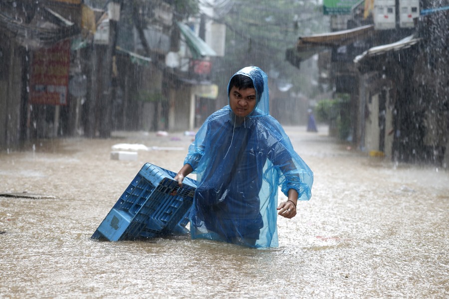 tifonyagi Un hombre camina a través de las aguas inundadas en Hanoi, Vietnam