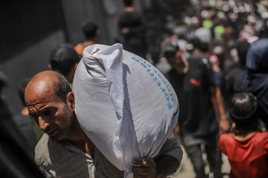 gaza-palestinos-reparto-comida Un palestino carga con un saco de harina en Gaza.
